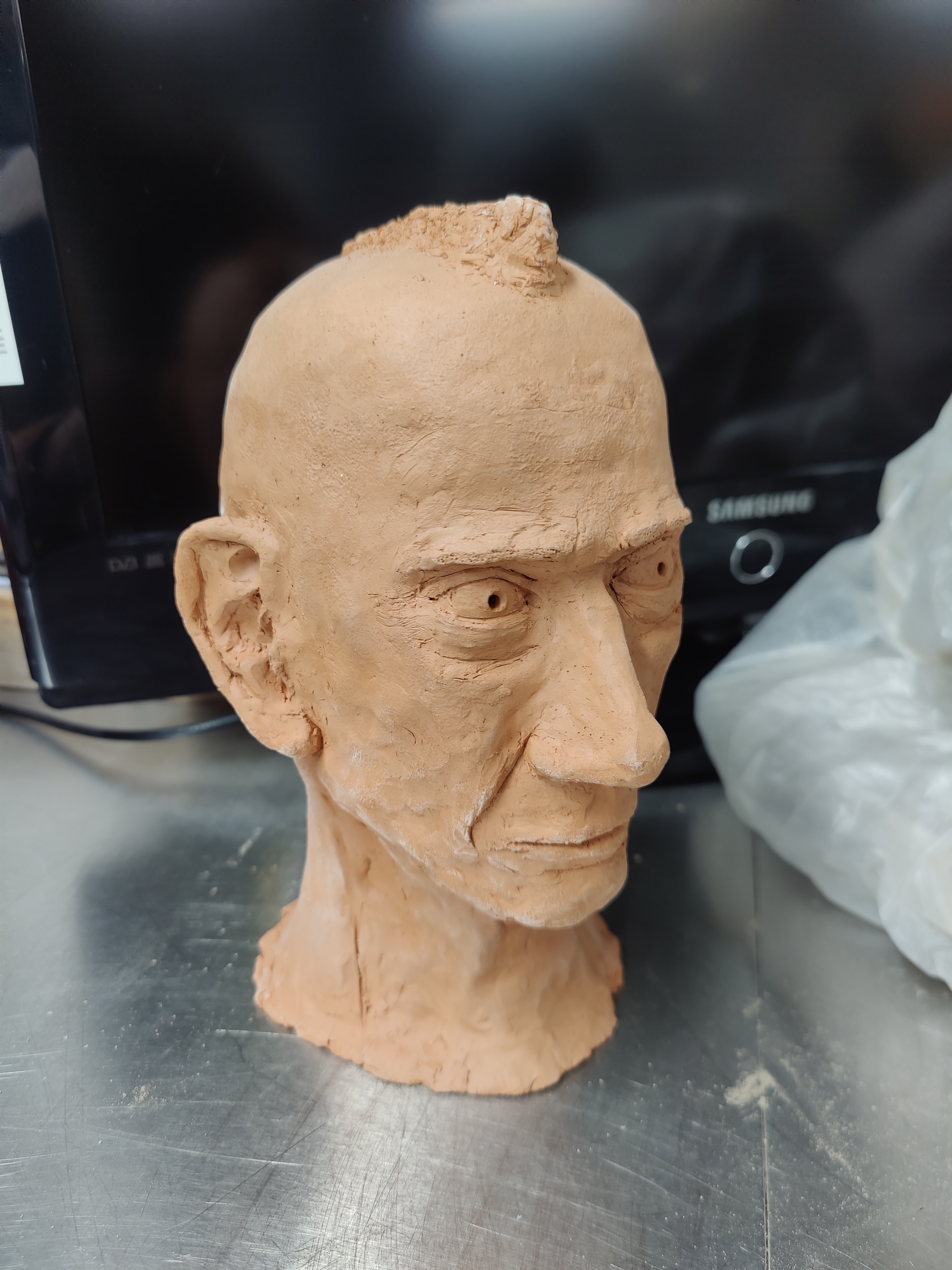 Terracotta clay head of an old man with a short mohawk hairstyle